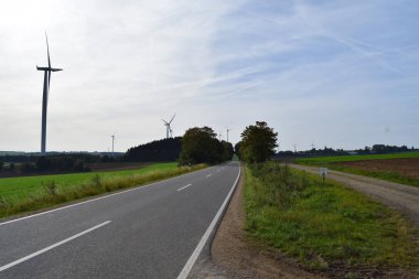 Kırsalda rüzgar türbini olan bir yol, alternatif enerji