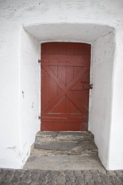 Ortaçağ şatosunda kırmızı saplı tahta bir kapı.