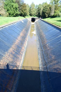 Kanaldaki eski paslı bir boru manzarası.