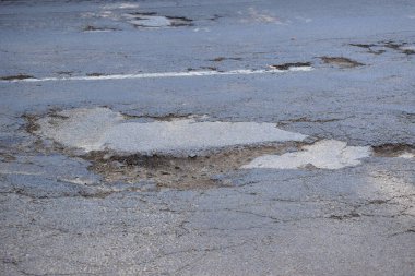 Asfalt yolda beyaz kar ve asfalt üzerinde beyaz lastik izleri var.