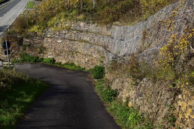 Ülkenin ortasında taştan bir yol olan dar bir caddenin dikey görüntüsü.