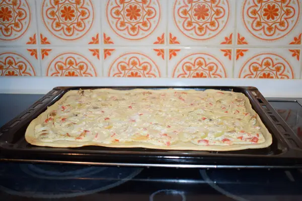 Ev yapımı Flammkuchen, krema, pastırma ve soğan sosu.