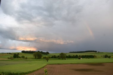 Gökkuşağı ve fırtına yeşil bir alanda