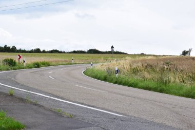Uzaklarda tarlaları olan bir köy yolu.