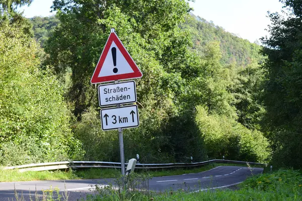 Dağlardaki yol tabelası, yol hasarı uyarısı