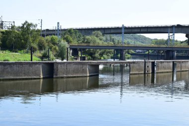 sluice wall and the bridges on two levels crossing each other and the Moselle in Thionville clipart