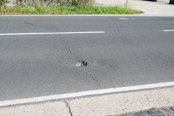 Çatlaklar ve çiziklerle asfalt yol