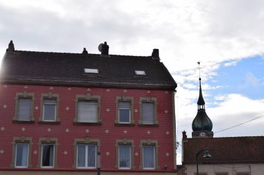 Pembe evi ve kilise kulesi olan eski bir Fransız kasabası.