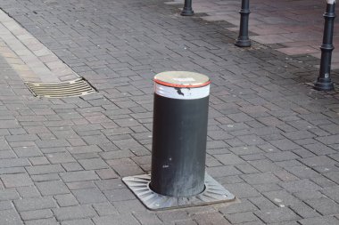 Yoldaki siyah beyaz çöp tenekesi.