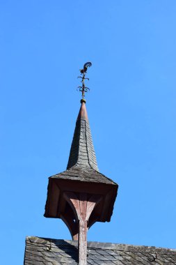 Mavi gökyüzü ve beyaz bulutlu güzel beyaz bir çatının dikey görüntüsü.