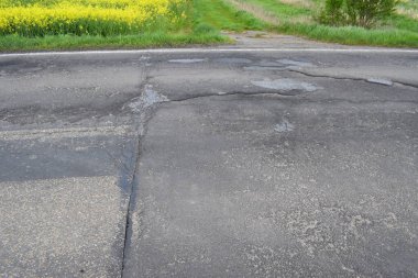 Asfaltta çatlaklar ve çatlaklar olan asfalt dokusu..