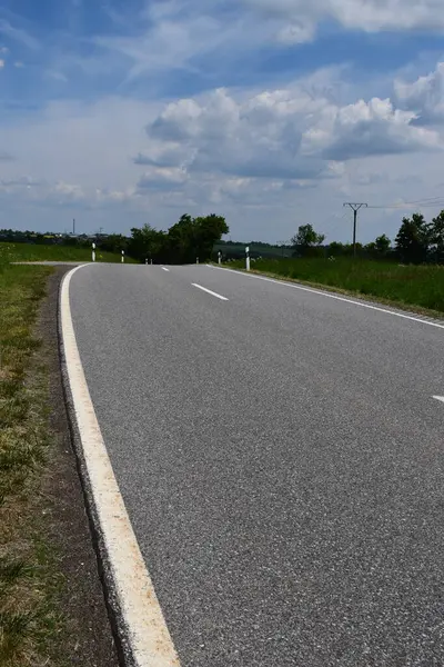Beyaz bulutlu asfalt yol ve mavi gökyüzü