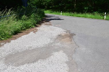 Asfalt yol ve bir sürü asfalt içeren beyaz asfalt yüzeyi. Yol yüzeyinde ve asfalt yüzeyinde çatlaklar var. yol onarımı.