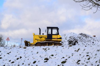 yellow tractor in the snow. clipart