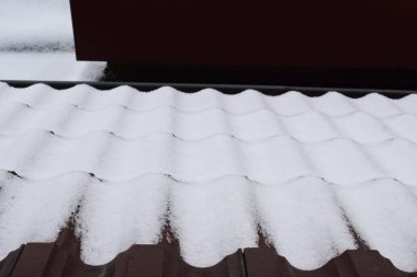 Kırmızı çatılı beyaz kar çatısı ve kışın ahşap evi.
