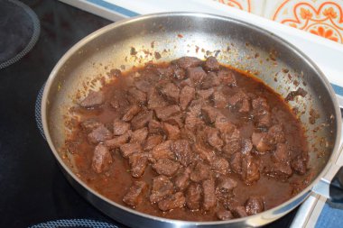 Bir tavanın dikey görüntüsü, siyah bir tavayla et ile birlikte.