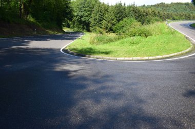 Güneşli bir günde yeşil çimenli asfalt yol