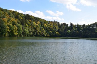 Yeşil ormanı ve mavi gökyüzü olan güzel göl.
