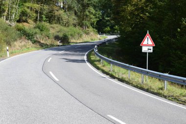 Ormanda bir sürü asfalt olan yol tabelası.