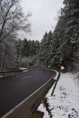 yol ve ağaçlar karla kaplı ve kış karıyla.