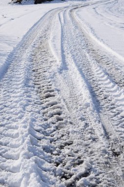 Kar kaplı araba tekerleği yolda.