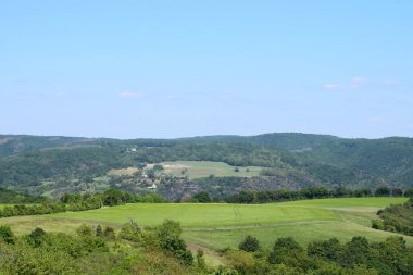 Thuringia ormanındaki koku köyünün tepelerini ve yeşil tarlalarını görüyorum.