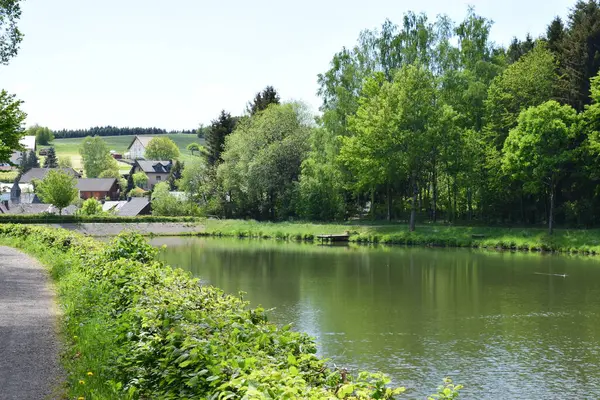 bir gölü olan kırsal manzaranın resimsel görüntüsü