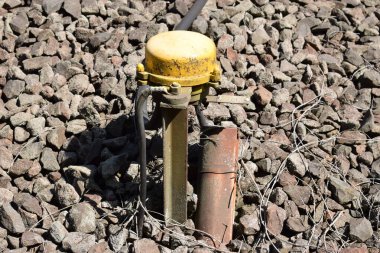 Sokaktaki paslı metal borunun dikey görüntüsü.