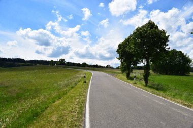 Almanya 'da yeşil ağaçlar ve mavi gökyüzü olan ülke manzarası