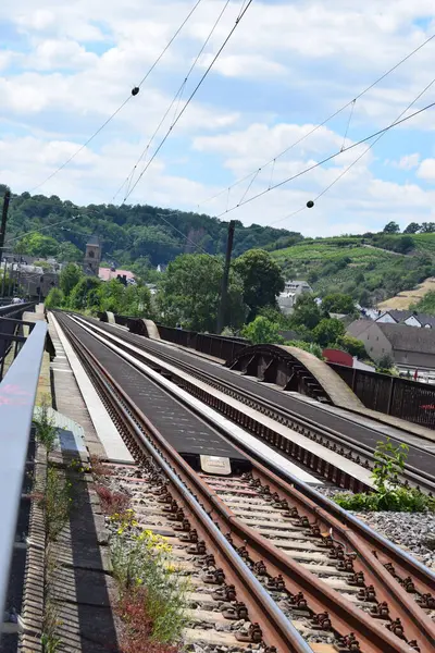 Tren istasyonunun arka planında raylar var.