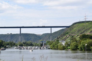 Köprü altında tekneleri olan Mosel Vadisi
