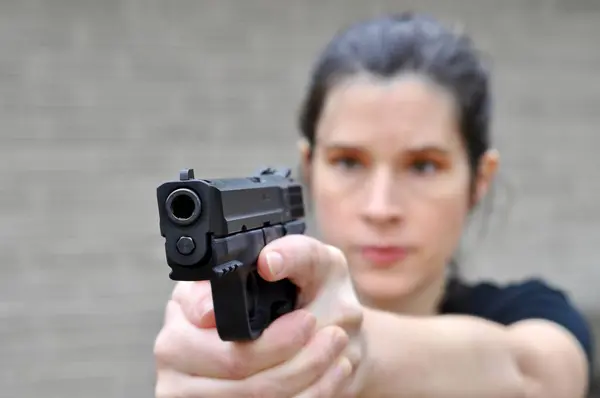 stock image Woman in background aims her pistol off camera