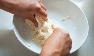 Bir kasede mısır unu yoğuran bir kadın.