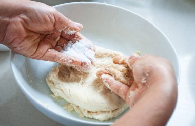 Bir kasede mısır unu yoğuran bir kadın.