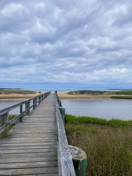 Tahta bir köprü, gökyüzünün altındaki bir sahile götürür..
