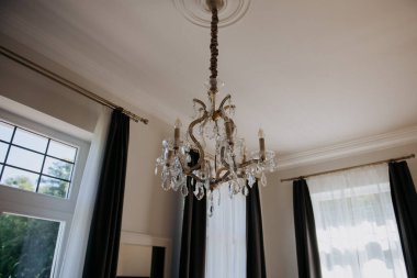 Güzel bir avize zarif bir şekilde güzel dekore edilmiş bir odanın tavanında asılı duruyor ve uzayın iç tasarımına cazibe katıyor.