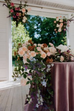 Yüzeyinde canlı çiçeklerle süslenmiş, arka plandan içeri doğal ışığın girmesine izin veren bir pencere ile tamamlanmış güzel bir masa.