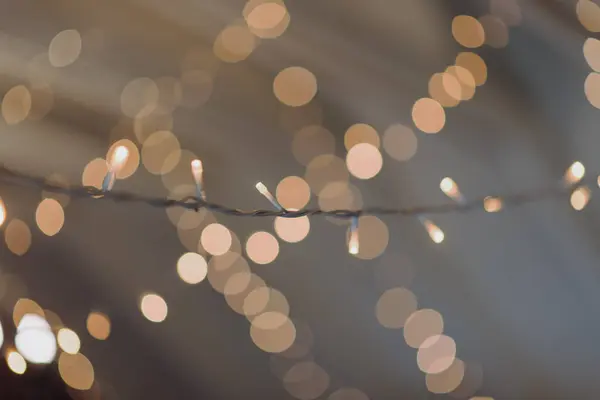 Ayrıntılı bir yakın çekim görüntüsü yukarıdaki tavandan sarkan bir dizi renkli Noel ışıklarını gösteriyor.