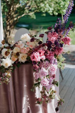 Yüzeyine zarif bir şekilde yerleştirilmiş pembe ve mor çiçekleri içeren güzel bir masa güzel bir görüntü oluşturur.