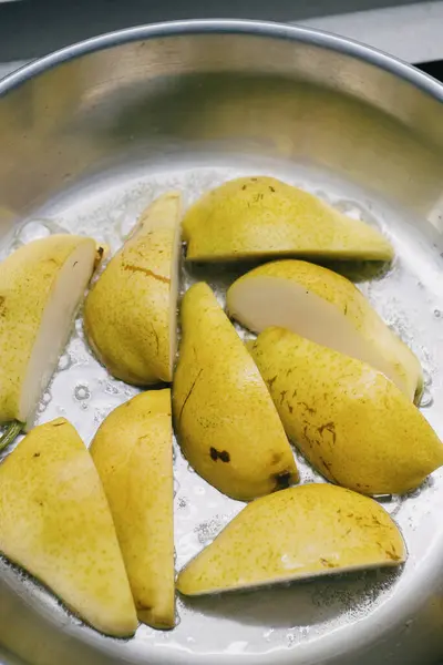 Taze dilimlenmiş, pırıl pırıl armutlar. Parlak gümüş bir tavada güzelce dizilmiş. Yemek pişirmek ya da zarif bir sunum için mükemmel.
