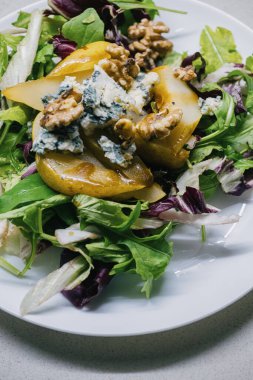Taze yeşilliklerden, sulu armutlardan, gevrek cevizlerden yapılmış canlı ve renkli bir salata.