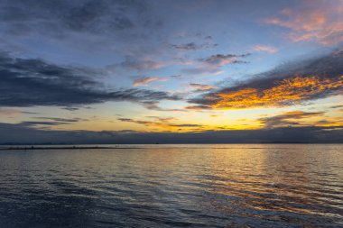 Sıradışı turuncu bulutlarla güzel bir gün batımı, Tayland sahilinin limanında..