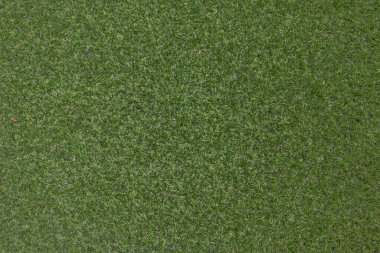 Yapay ot, kaplama. Yapay yeşil çimen paspası, üst manzara. Doku. Geçmişi. Suni çim, yapay liflerden yapılmış yüzey. Düz yeşil çimen dokusu. Kısa çimenler. Stok fotoğrafı