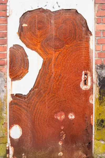 stock image Eroded and Decayed Red Rusty Door with Peeled White Paint Texture