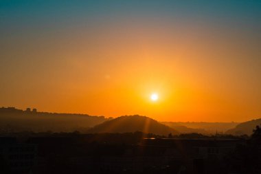Parlak güneş ışığı manzaranın üzerindeki gökyüzünü aydınlatır