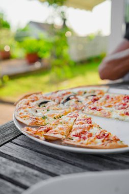 Sıcak bir yaz gününde bir tabakta Fransız Tarte Flambee dilimleri