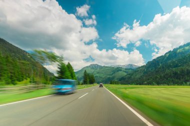 Caddedeki güzel bir dağ manzarasında hızla seyahat ediyor.