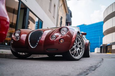 Front of a Rare Red Sportscar Parking on the City Street Sideway Viewed From the Bottom up clipart