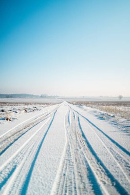 Güneşli bir kış gününde Kar 'a Lastik İzleri Yazdırılmış Yol