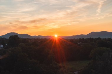 Güneş Batıyor Dağ Ufkusu 'nun ardında Orman manzarasına Orange Sunshine döküyor